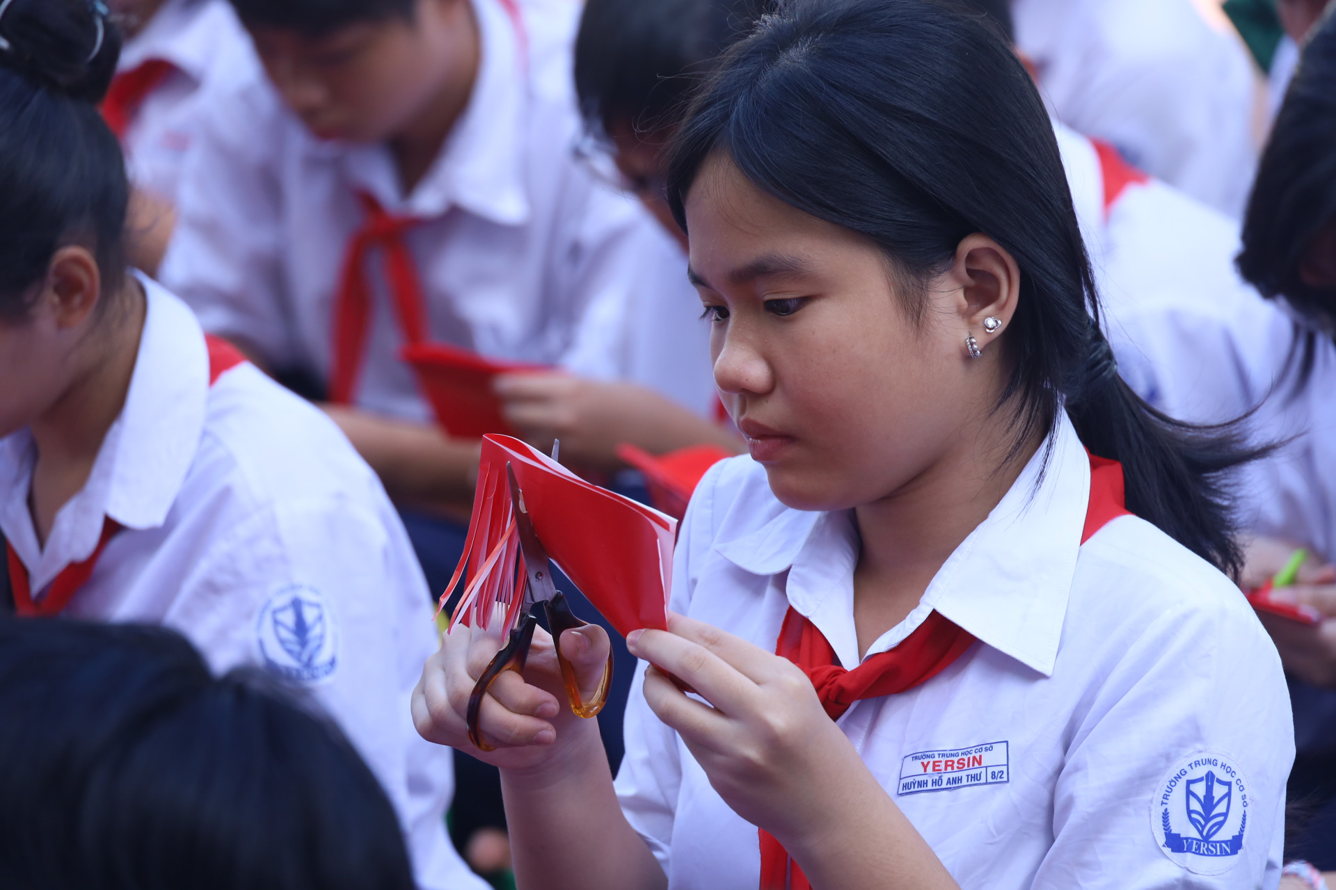 Từ những mảnh giấy màu đỏ, các em học sinh cắt dán, tạo hình nên những chiếc lồng đèn giấy.