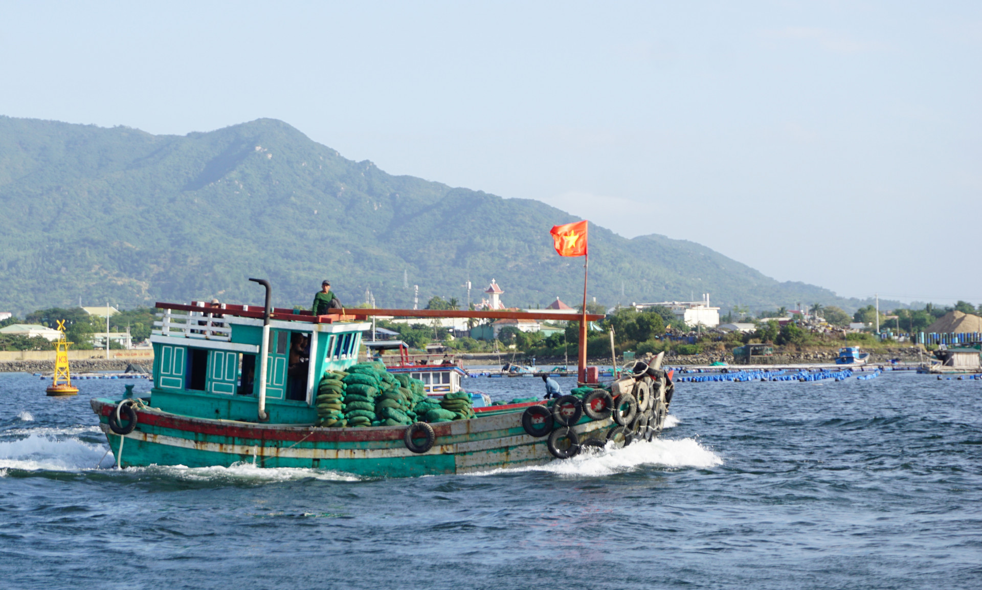 Một tàu chở thức ăn ra vùng nuôi thủy sản trên vịnh Cam Ranh.