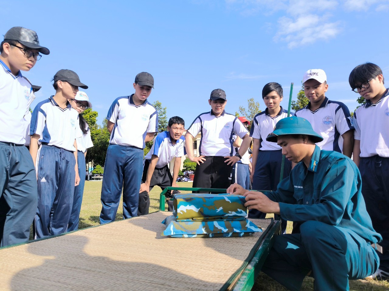 Các em học sinh tham quan và thực hành gấp chăn, màn.