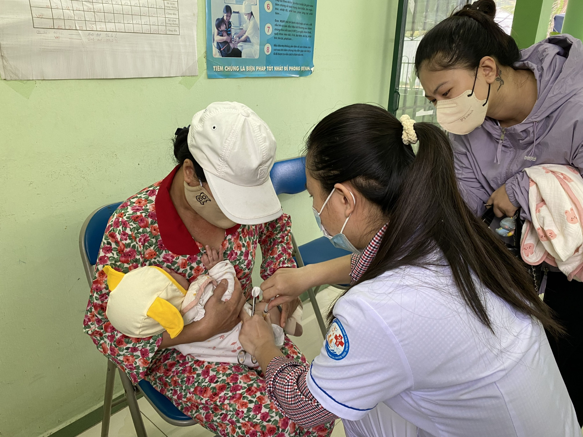 Cán bộ y tế Trạm Y tế xã Vĩnh Thái tiêm vắc xin cho trẻ.