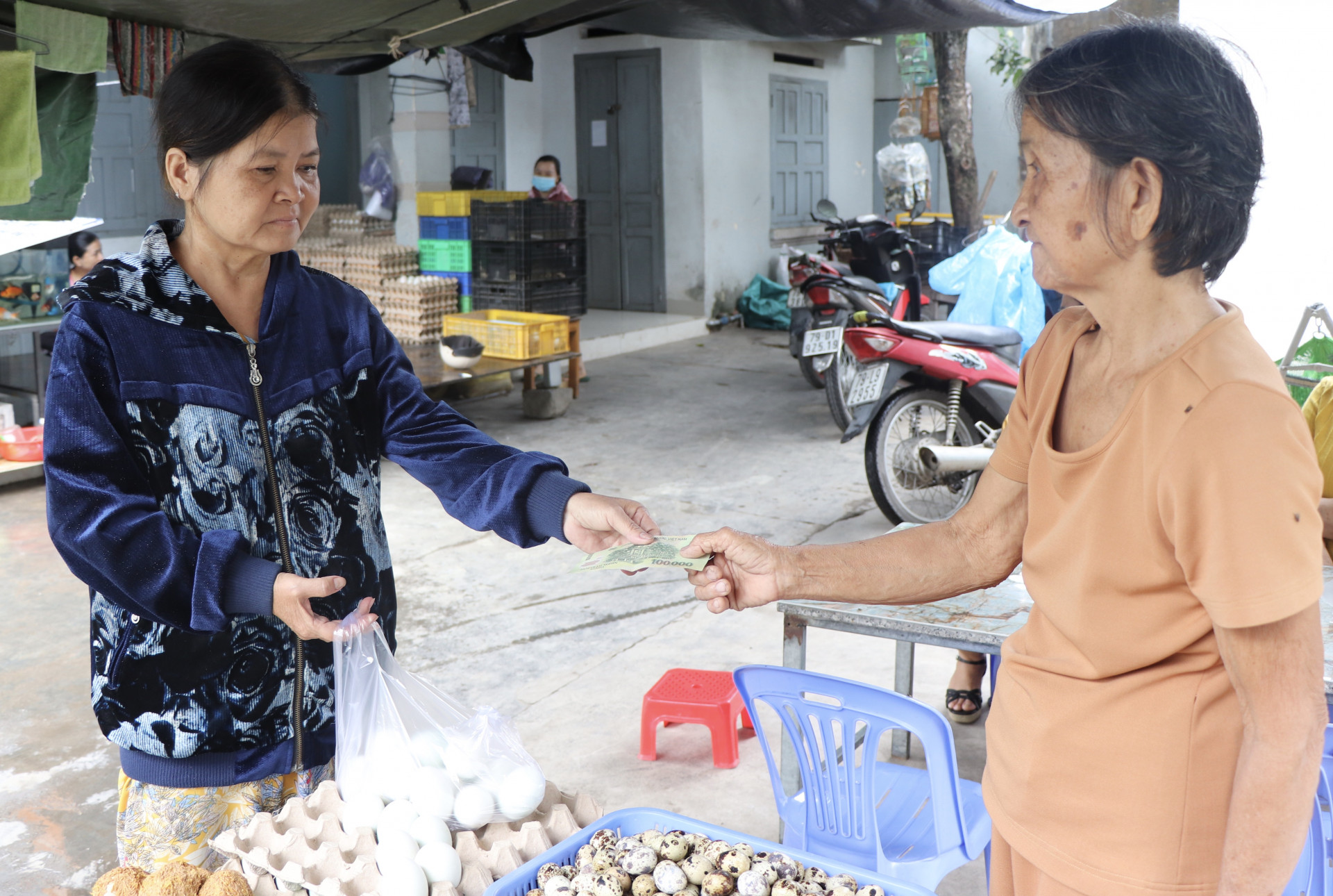 Bà Nguyễn Thị Năm (bên phải) bán hàng cho khách.