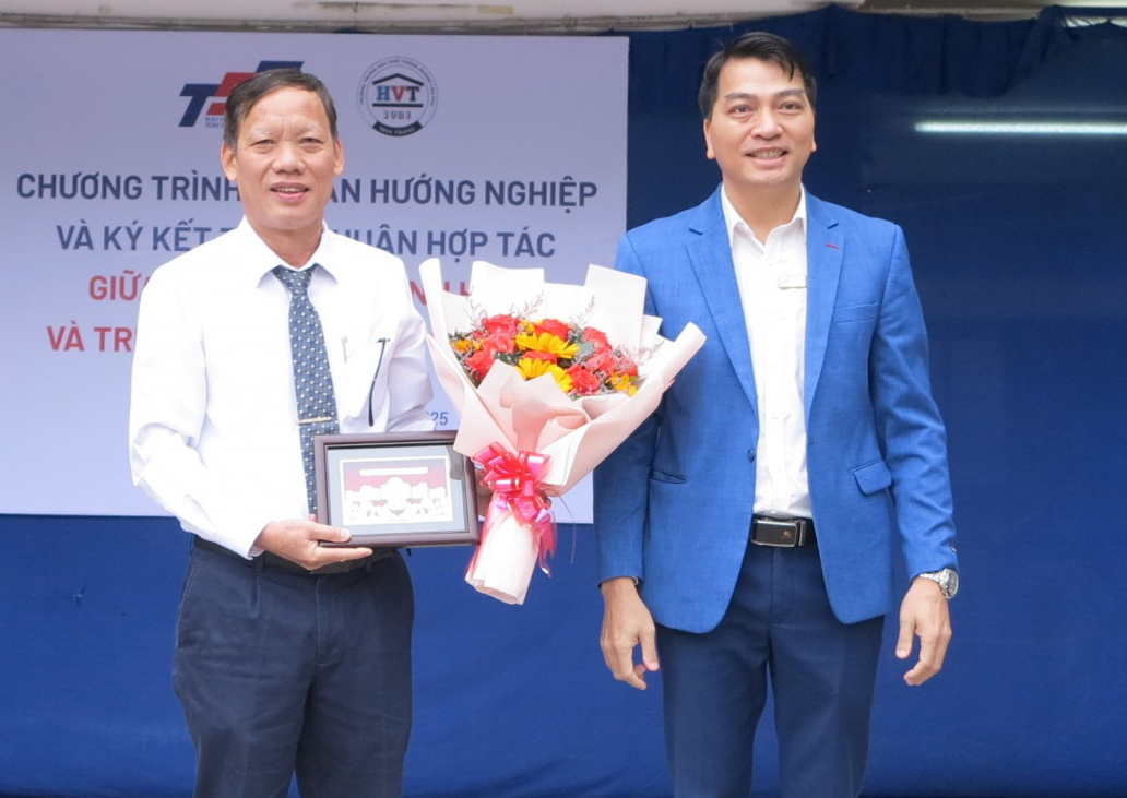 Đại diện Trường Đại học Tôn Đức Thắng Phân hiệu Khánh Hòa (bên phải) tặng hoa và quà lưu niệm cho Trường THPT Hoàng Văn Thụ.