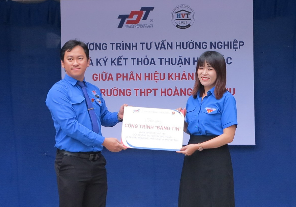 Đại diện Đoàn trường Đại học Tôn Đức Thắng (bên trái) trao bảng tượng trưng công trình thanh niên cho Đoàn trường THPT Hoàng Văn Thụ.