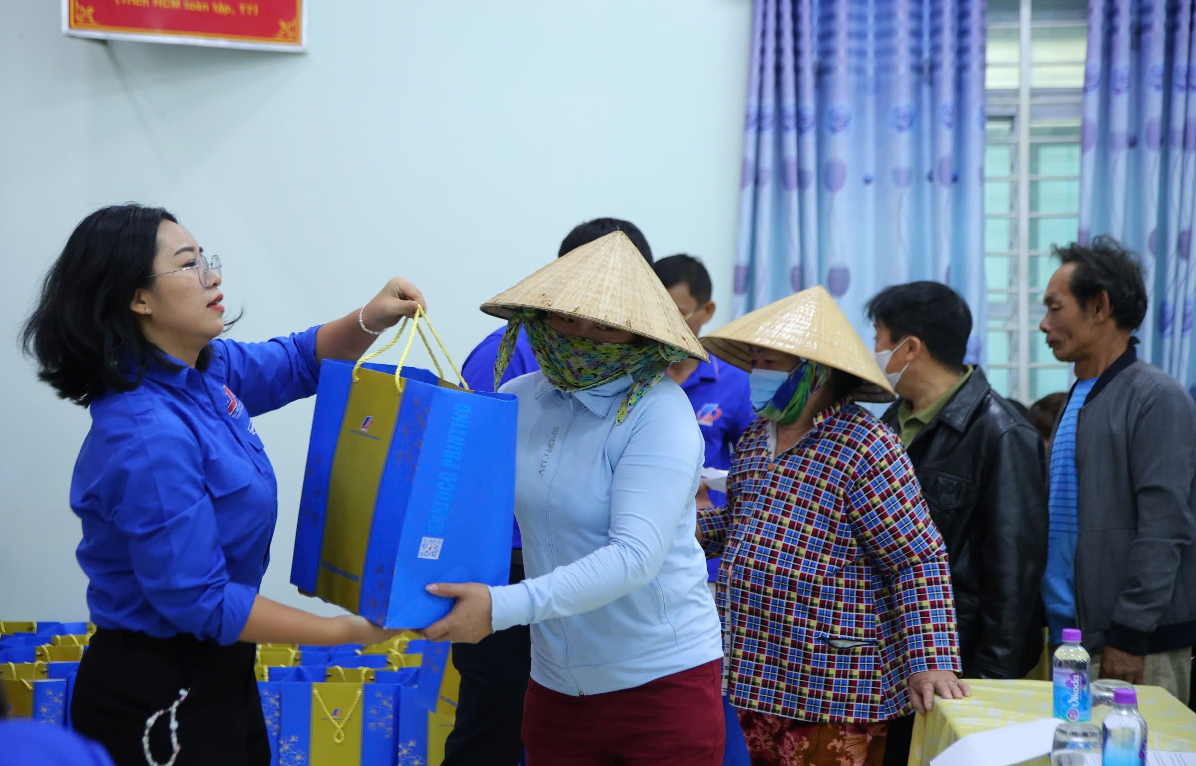 Đại diện Công đoàn cơ sở Công ty Cổ phần In bao bì Khatoco trao quà cho người dân.