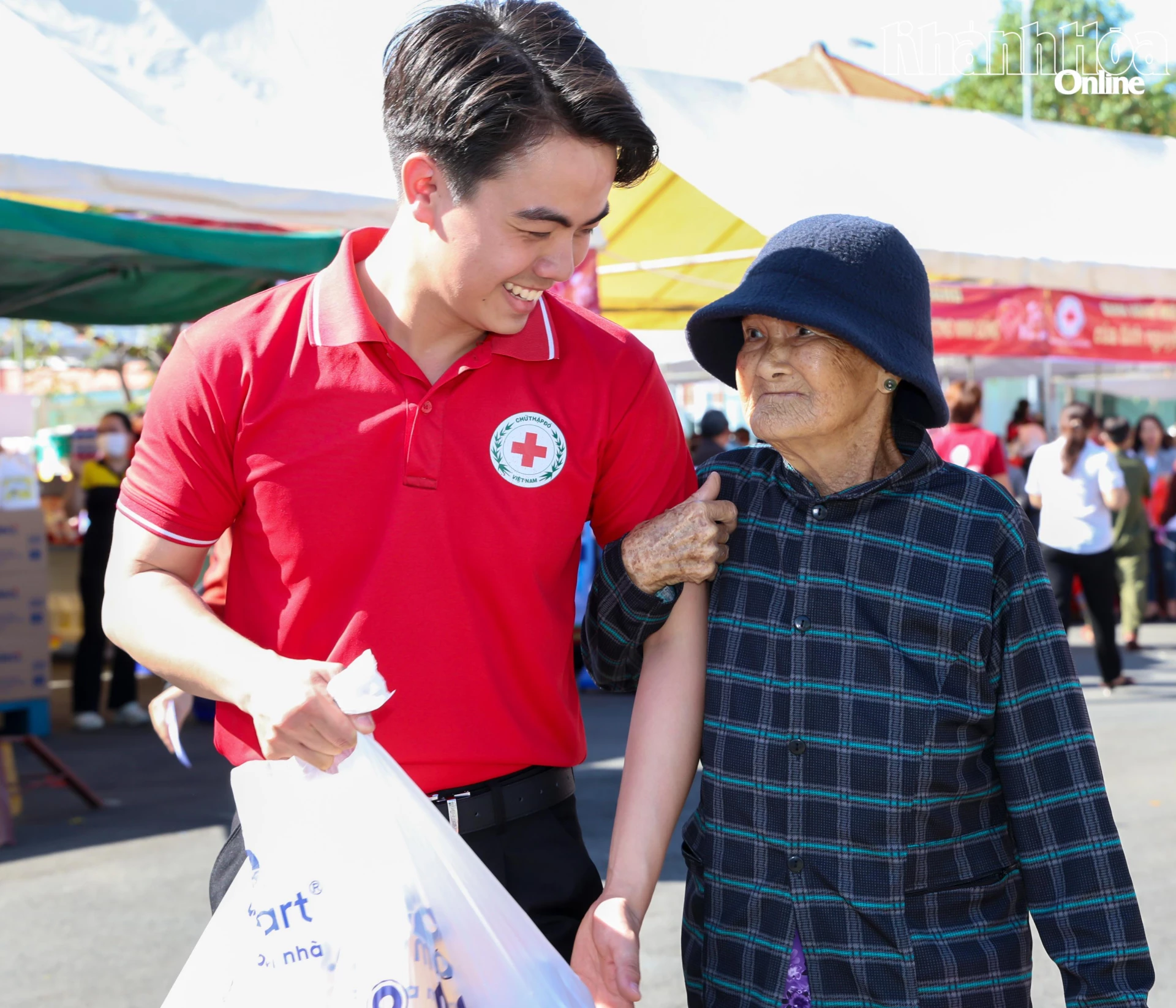 Một tình nguyện viên Hội Chữ thập đỏ hỗ trợ vận chuyển quà cho người già.