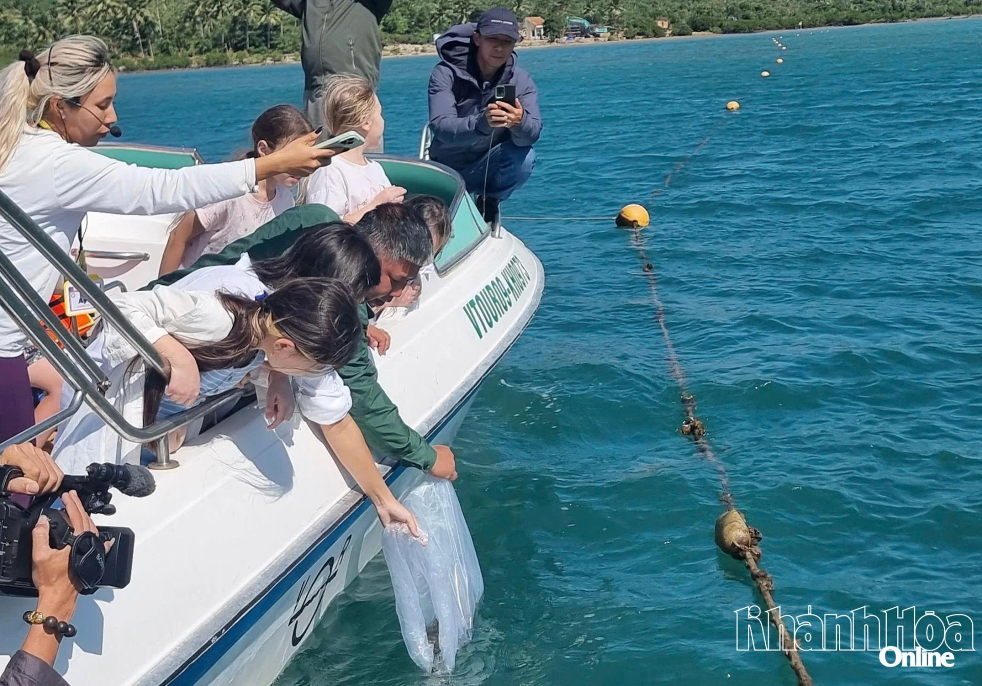 Du khách tham gia thả cá giống ở vịnh Nha Trang.