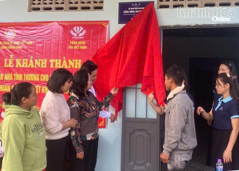 Các đại biểu thực hiện nghi thức kéo băng khánh thành nhà.