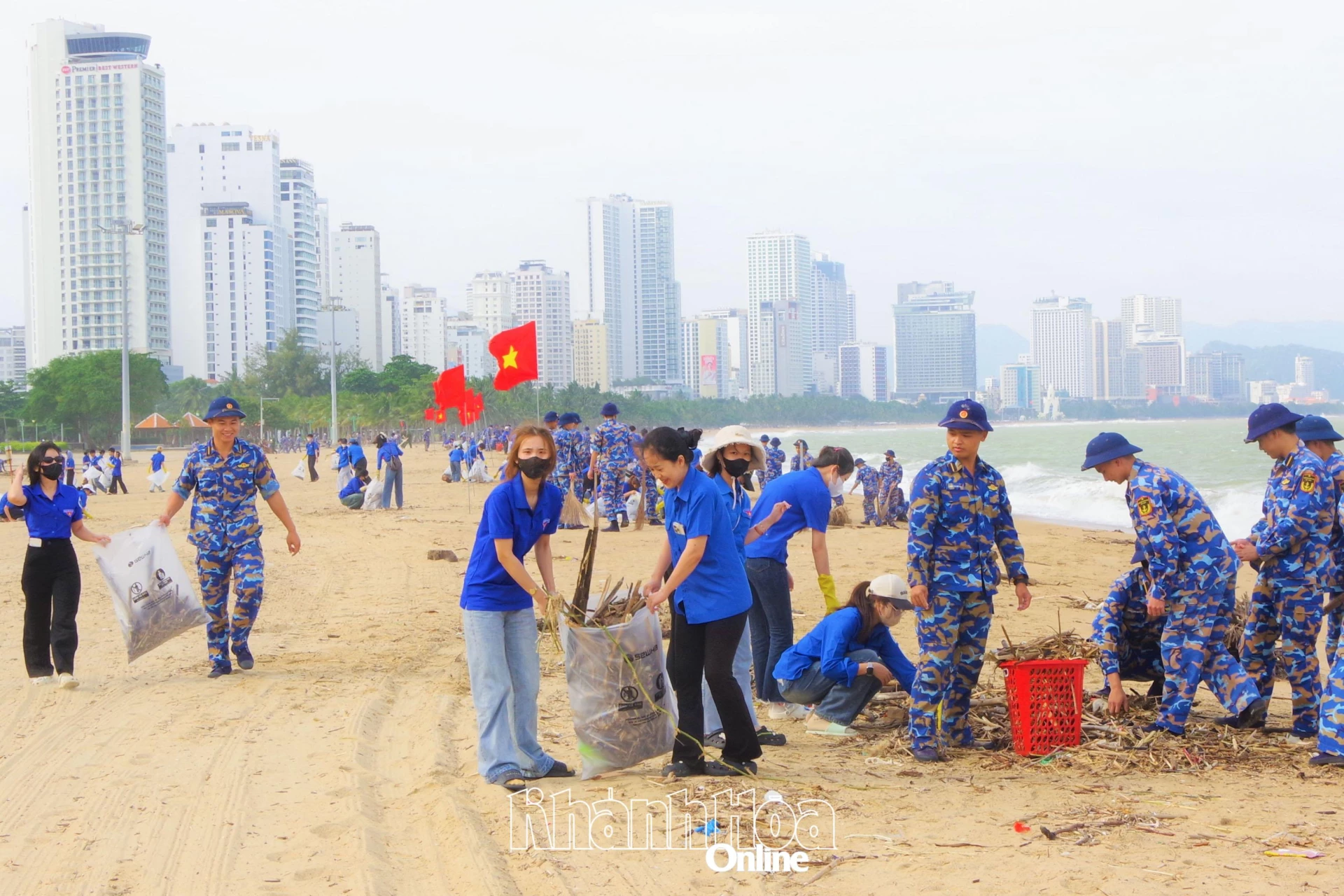 Sinh viên Trường Đại học Khánh Hòa và học viên Học viện Hải quân vệ sinh bãi biển sau mưa lũ.