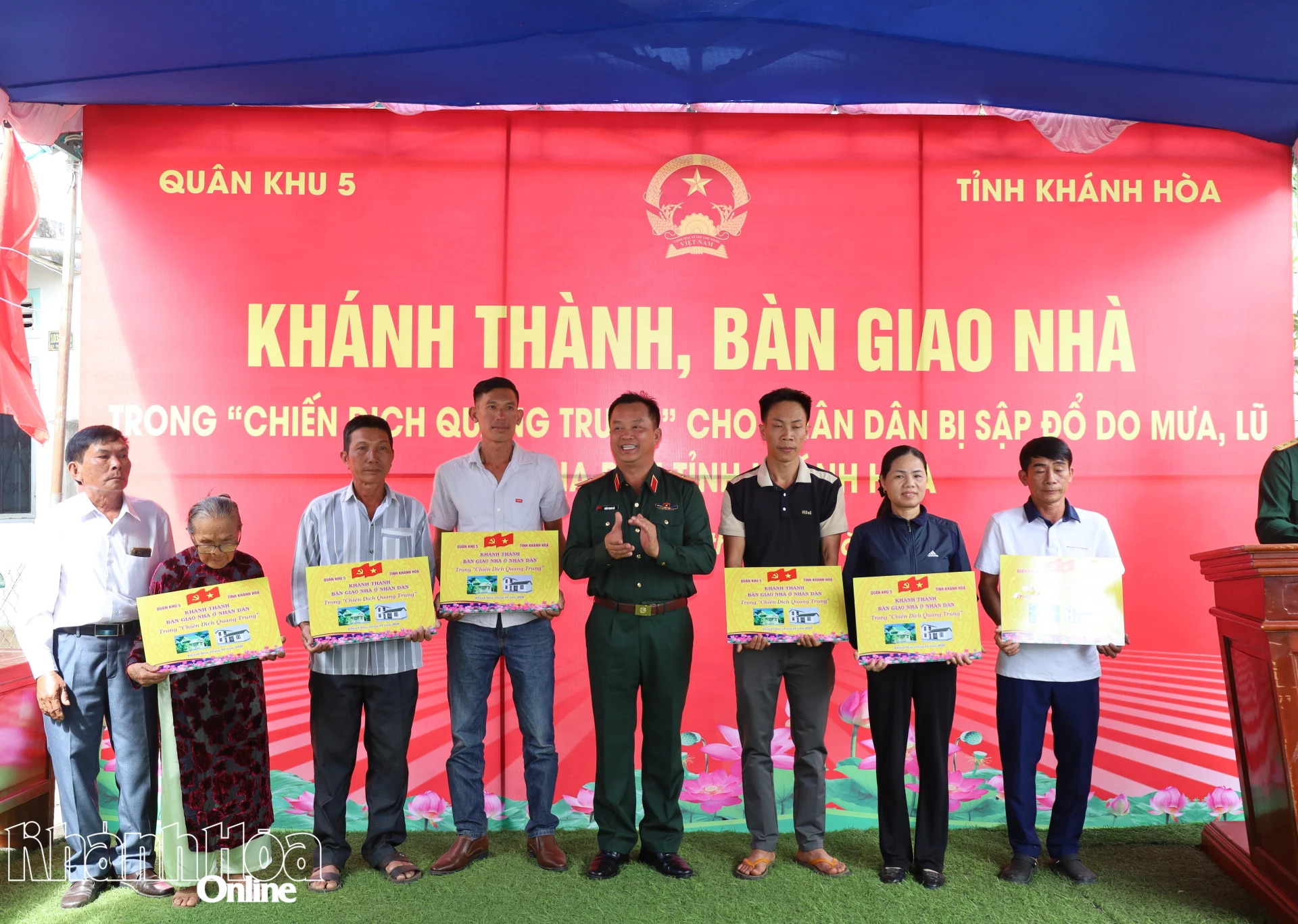 Thiếu tướng Trần Thanh Hải trao bảng bàn giao nhà cho các gia đình.