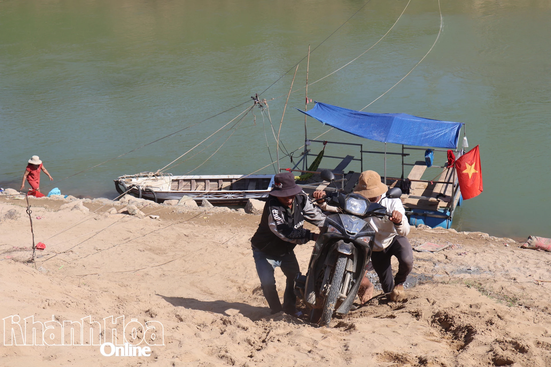 Người dân Khánh Vĩnh đẩy xe máy lên sau khi qua sông.