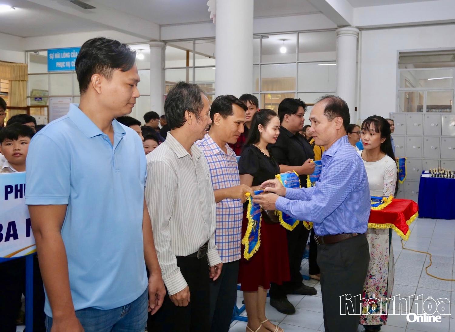 Ông Nguyễn Tuấn Thanh-Phó Giám đốc Sở Văn hóa, Thể thao và Du lịch, Trưởng Ban tổ chức giải (bên phải) trao cờ lưu niệm cho các đơn vị về dự giải.