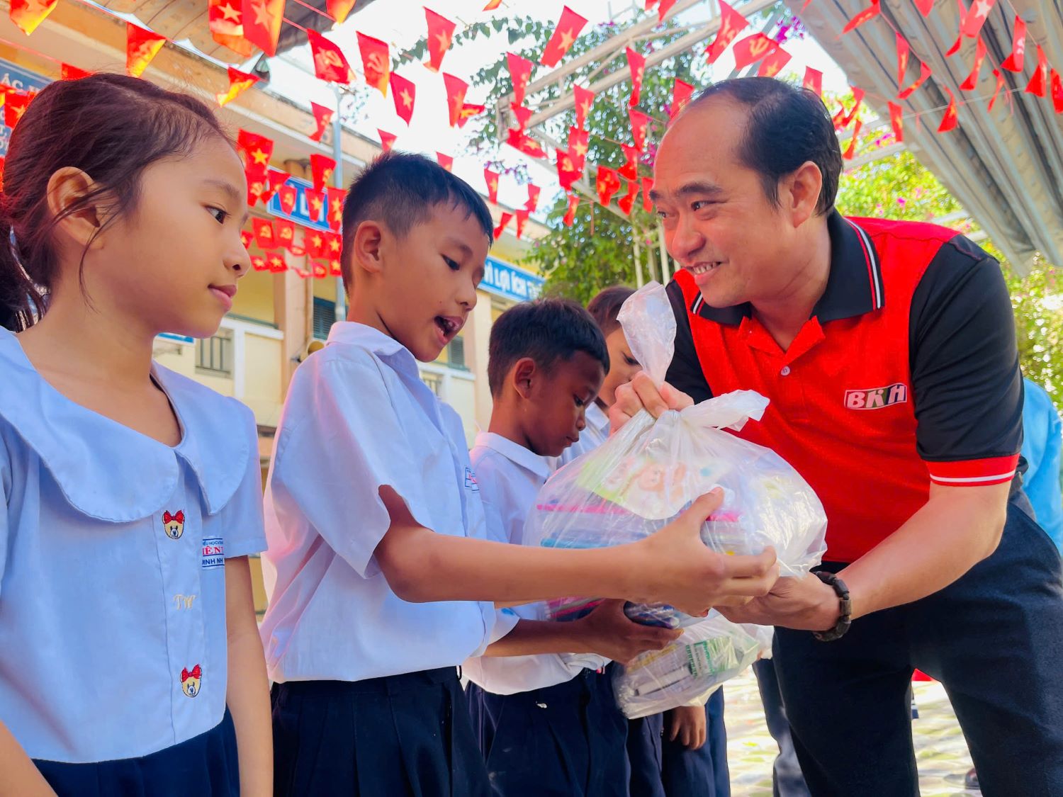 Lãnh đạo Báo và Phát thanh, Truyền hình Khánh Hòa trao quà cho các em học sinh.