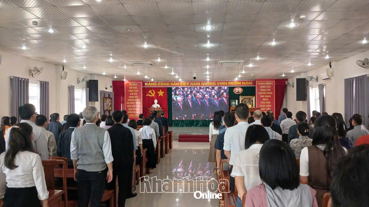 Cán bộ, đảng viên Đảng bộ Viện Pasteur Nha Trang thực hiện nghi thức chào cờ theo chương trình truyền hình trực tiếp của Đại hội Đảng. Ảnh: P.T.