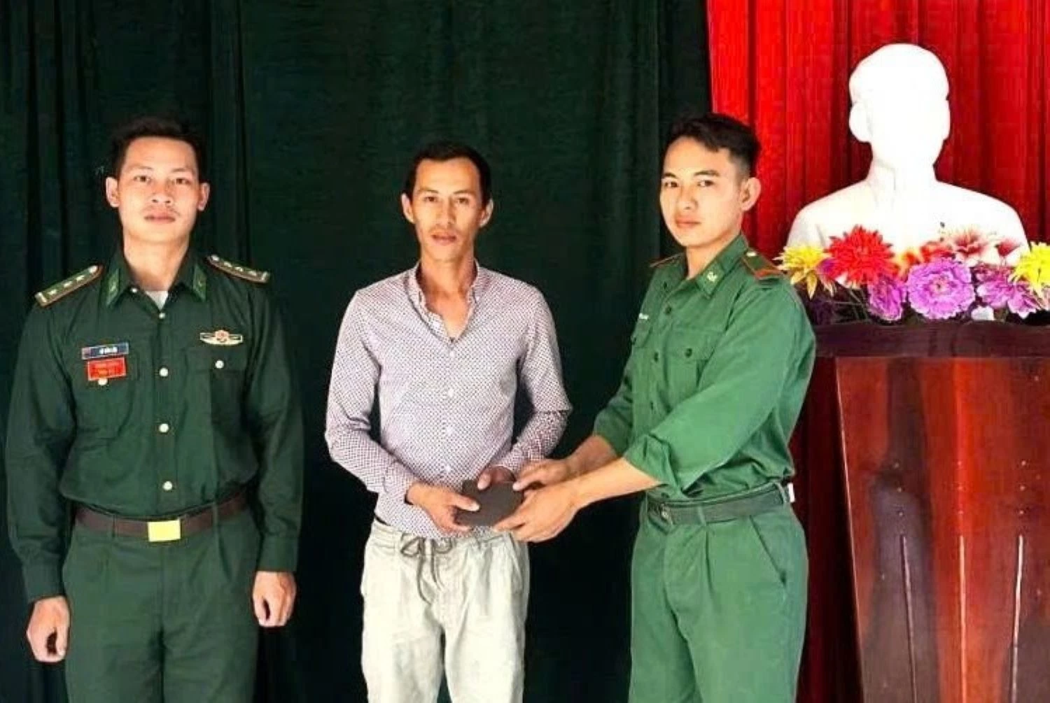 Chiến sĩ Nguyễn Trường Thông trao trả chiếc ví cho anh Nguyễn Ngọc Tuy trước sự chứng kiến của chỉ huy đơn vị.