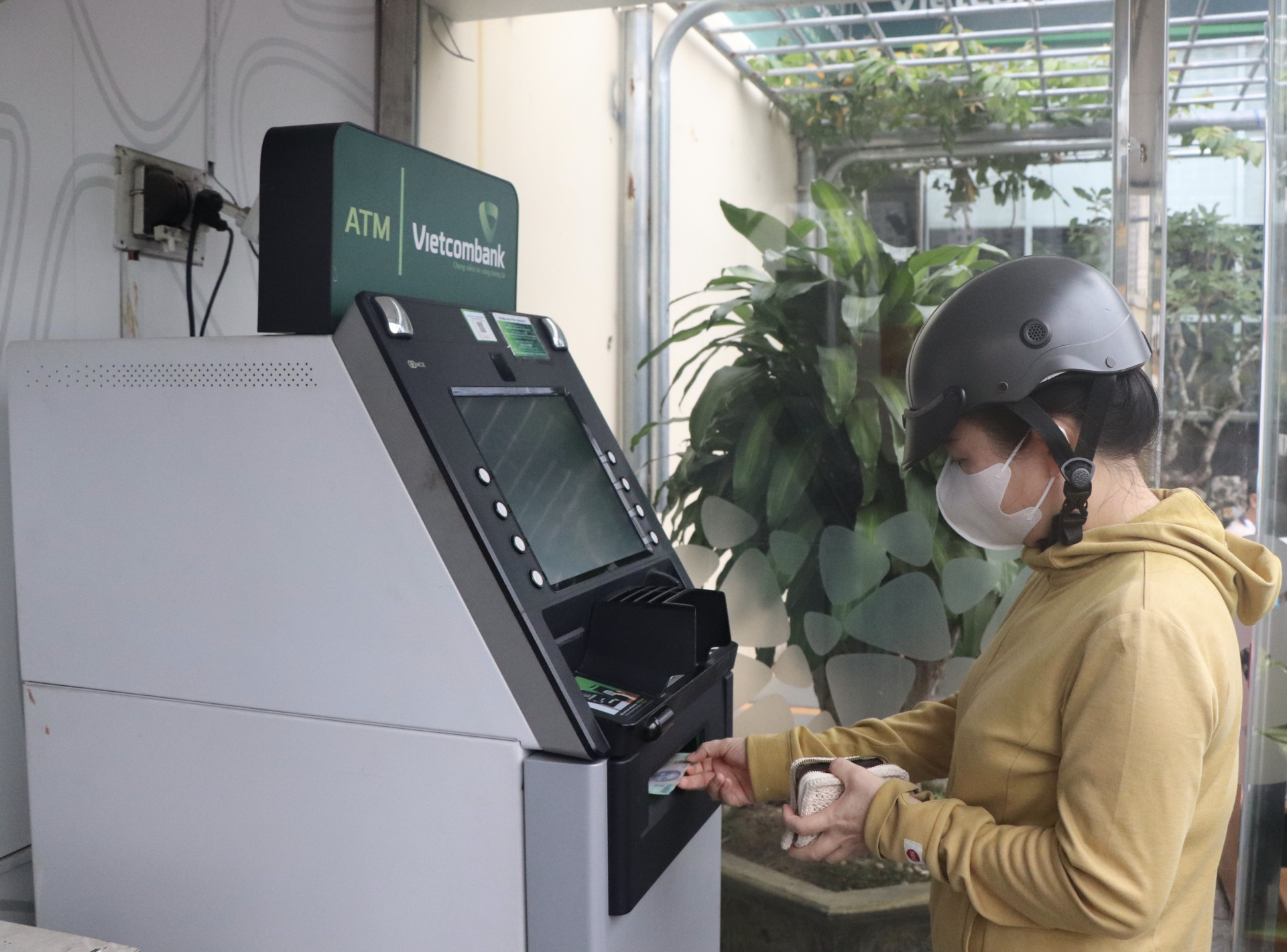 Người dân rút tiền mặt tại một trụ ATM ở TP. Nha Trang.