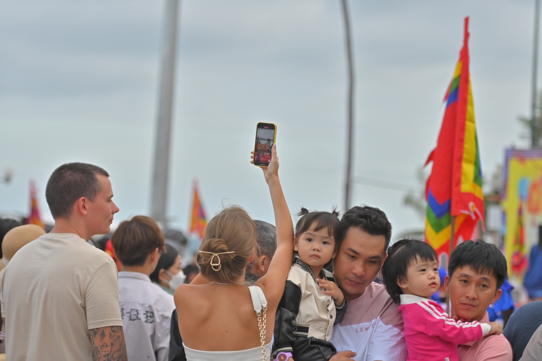 Foreign tourists recording the match

