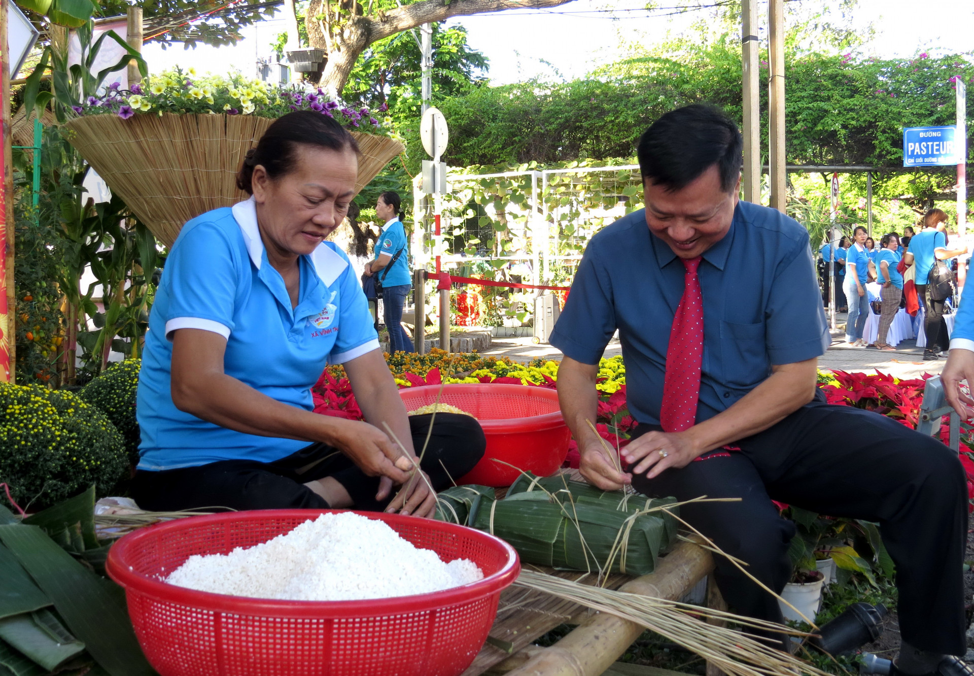 Ông Trần Xuân Lãm - Phó Bí thư Thường trực Thành ủy Nha Trang cùng thực hiện gói bánh với hội viên phụ nữ trong buổi khai mạc chương trình.