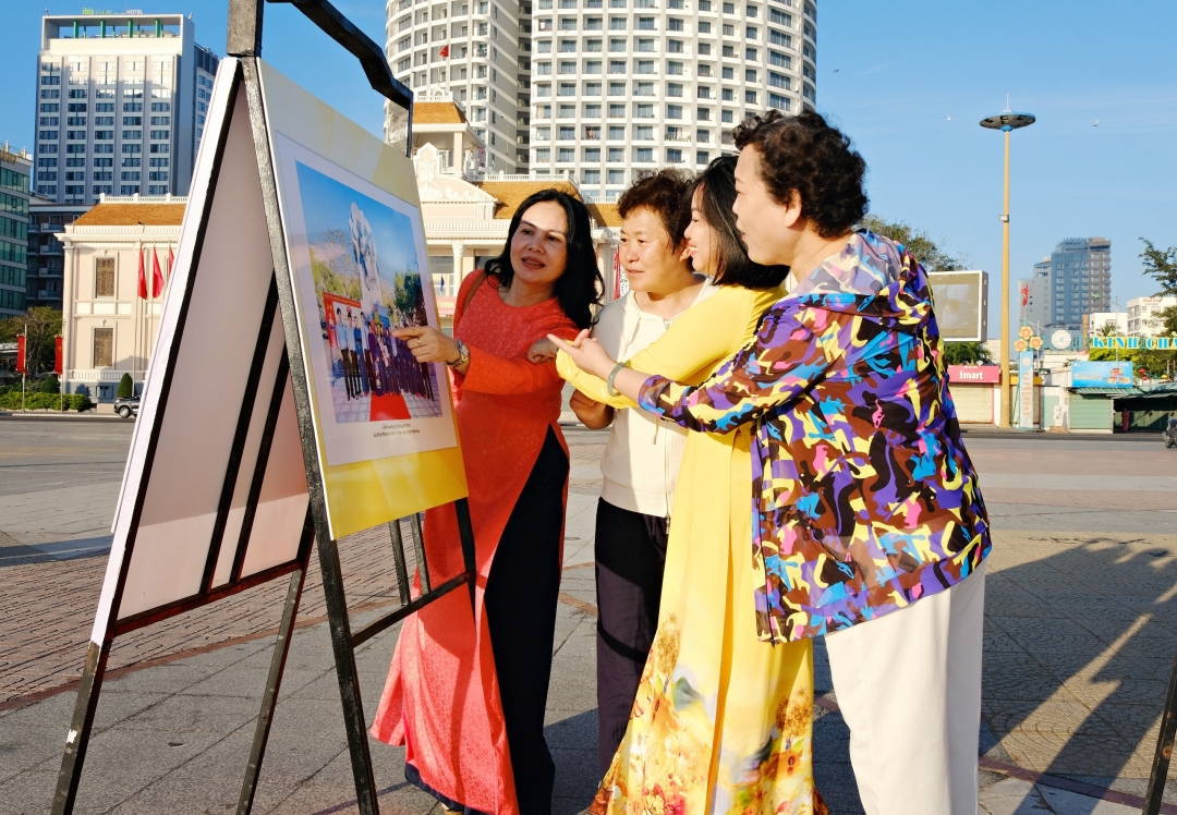 Các du khách nước ngoài cùng lãnh đạo Báo Khánh Hòa xem ảnh lễ kết nạp đảng viên ở Tượng đài 23 tháng 10 (TP. Nha Trang) của Đảng bộ Báo Khánh Hòa tại triển lãm ảnh Kết nạp Đảng ở các địa chỉ đỏ.
