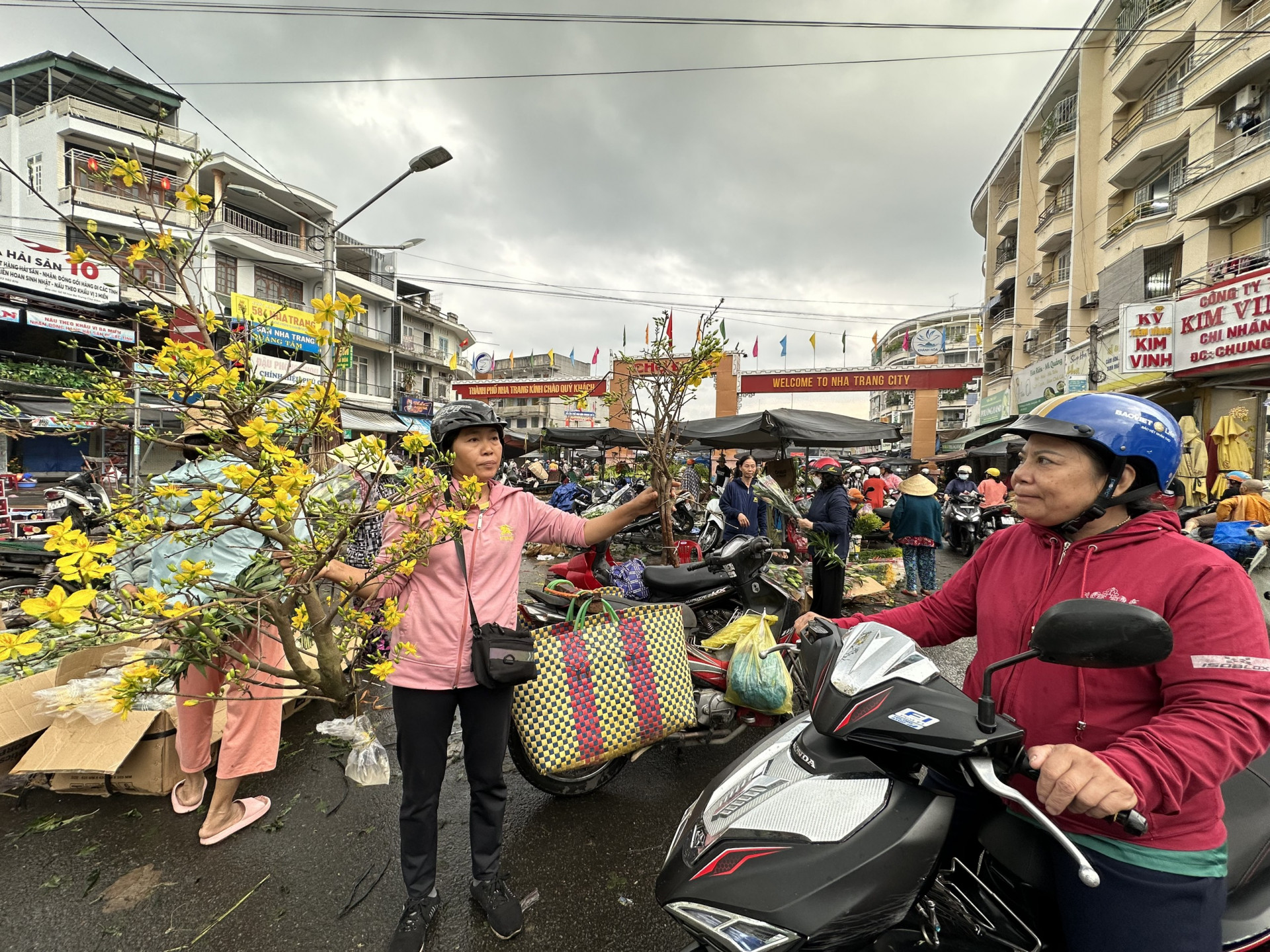  Người phụ nữ bán 2 cành mai giá 400 nghìn và 100 nghìn sáng 30 tết trước chợ Đầm.