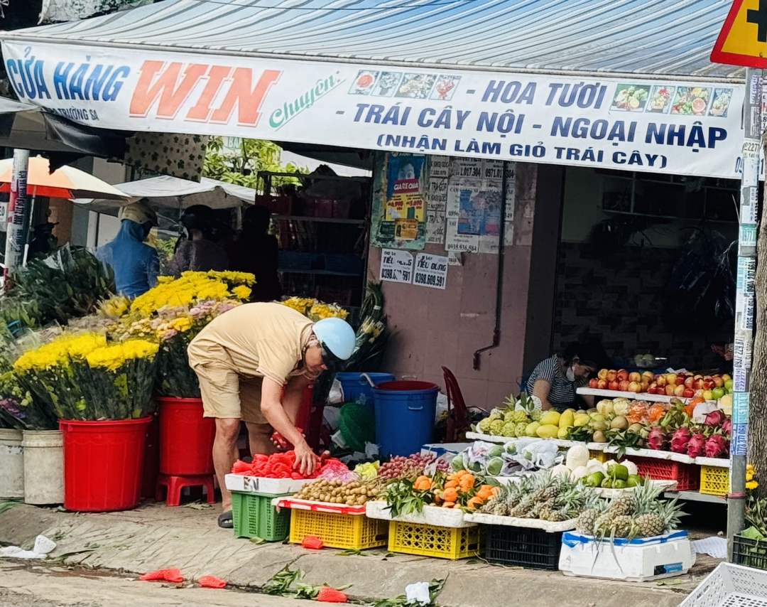 Khách chọn mua trái cây tại một sạp hàng gần chợ Phước Thái