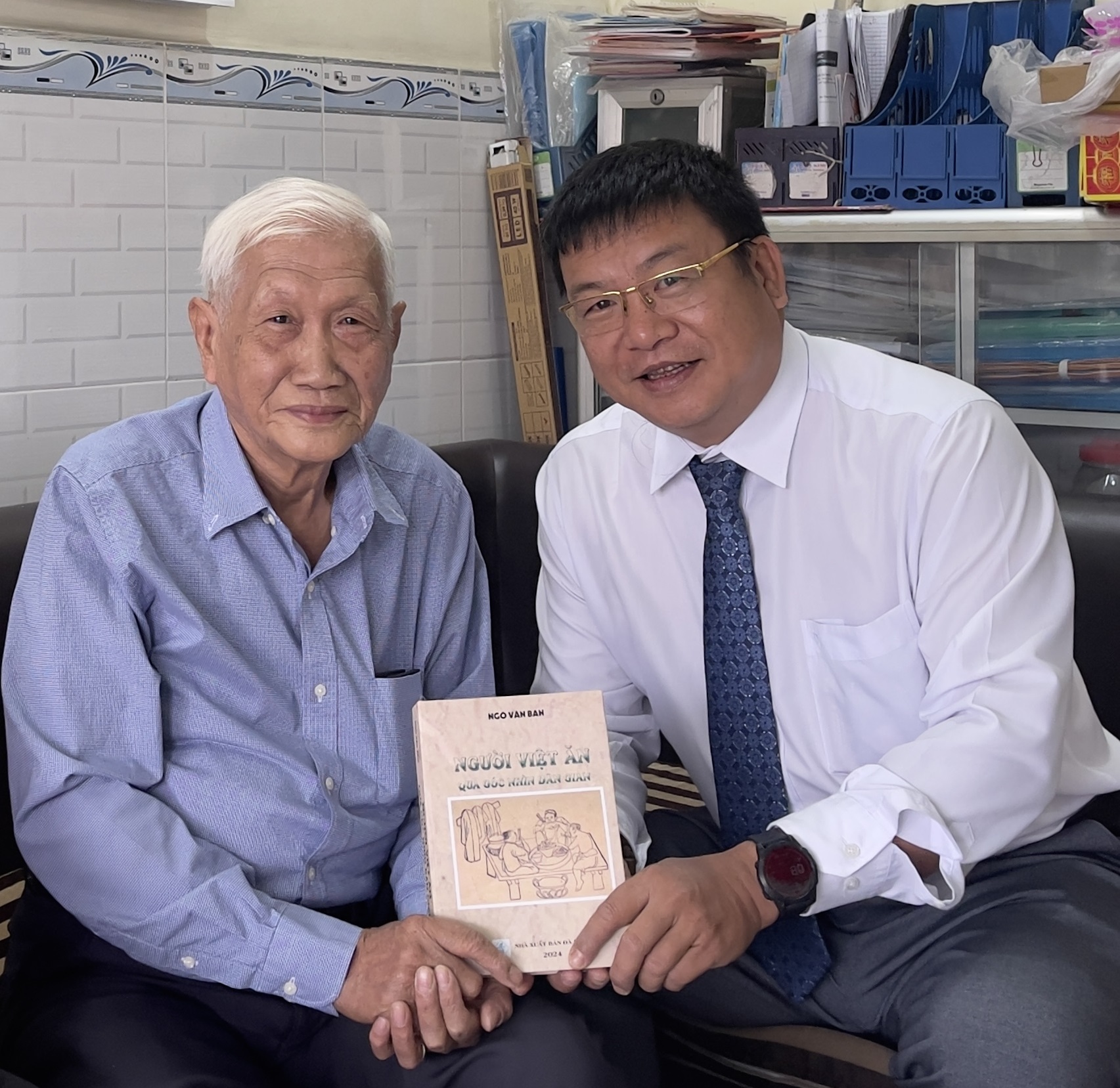 Nhà giáo ưu tú Ngô Văn Ban tặng cuốn sách do ông là tác giả cho lãnh đạo Sở Giáo dục và Đào tạo. 