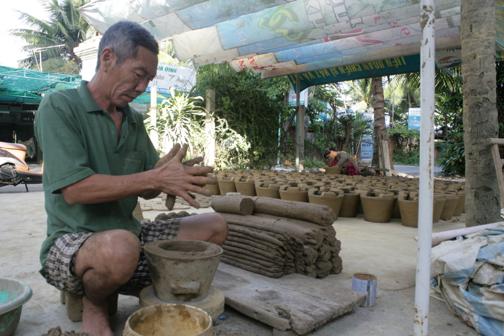 Một người dân làng gốm Lư Cấm 
đang tạo hình cho chiếc lò. (Ảnh chụp năm 2012)