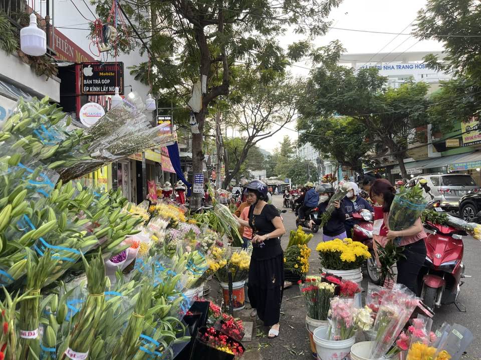 Người dân mua sắm tại một cửa hàng hoa gần chợ Phước Thái chiều 28 Tết
