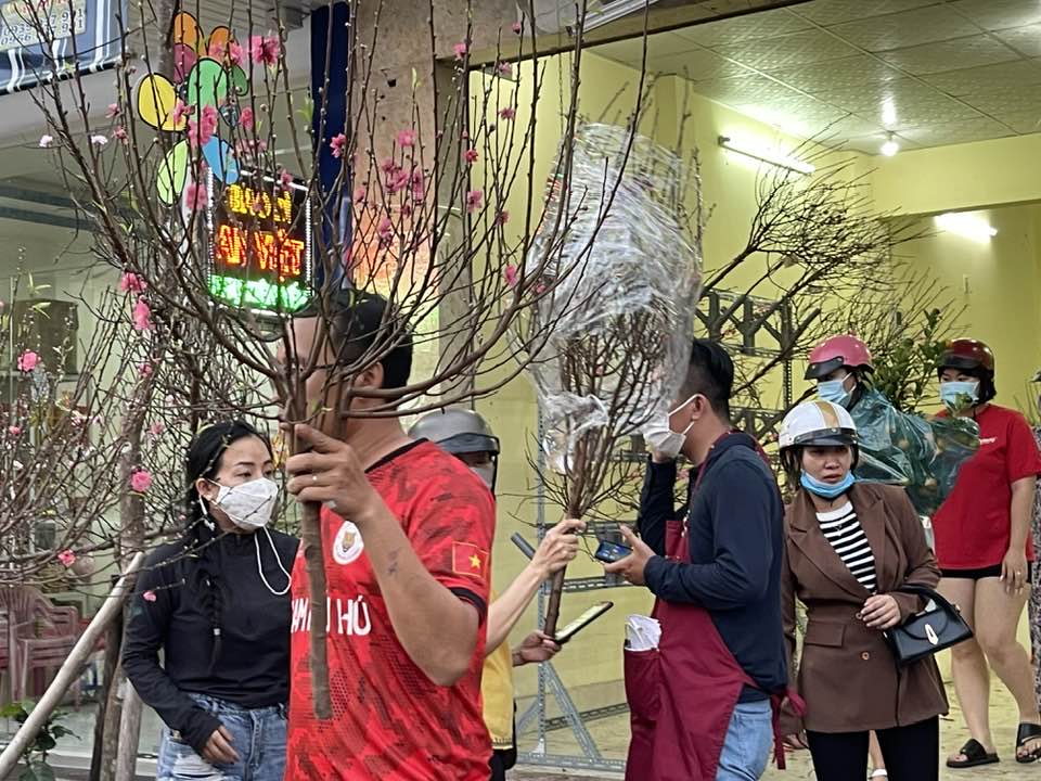 People buying peach blossoms 
