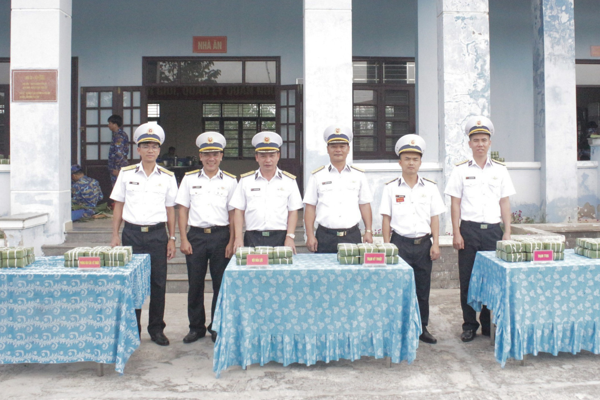 Ban giám khảo chấm điểm thi gói bánh chưng.