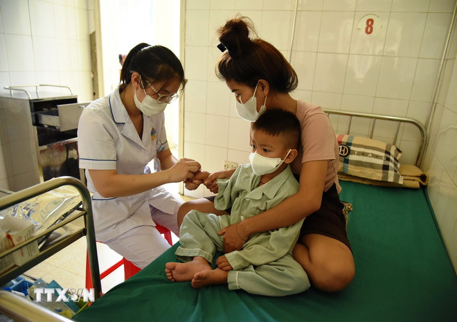 Nhiều trẻ nhỏ bị cúm phải đến bệnh viện điều trị. (Ảnh: Phan Quân/TTXVN)