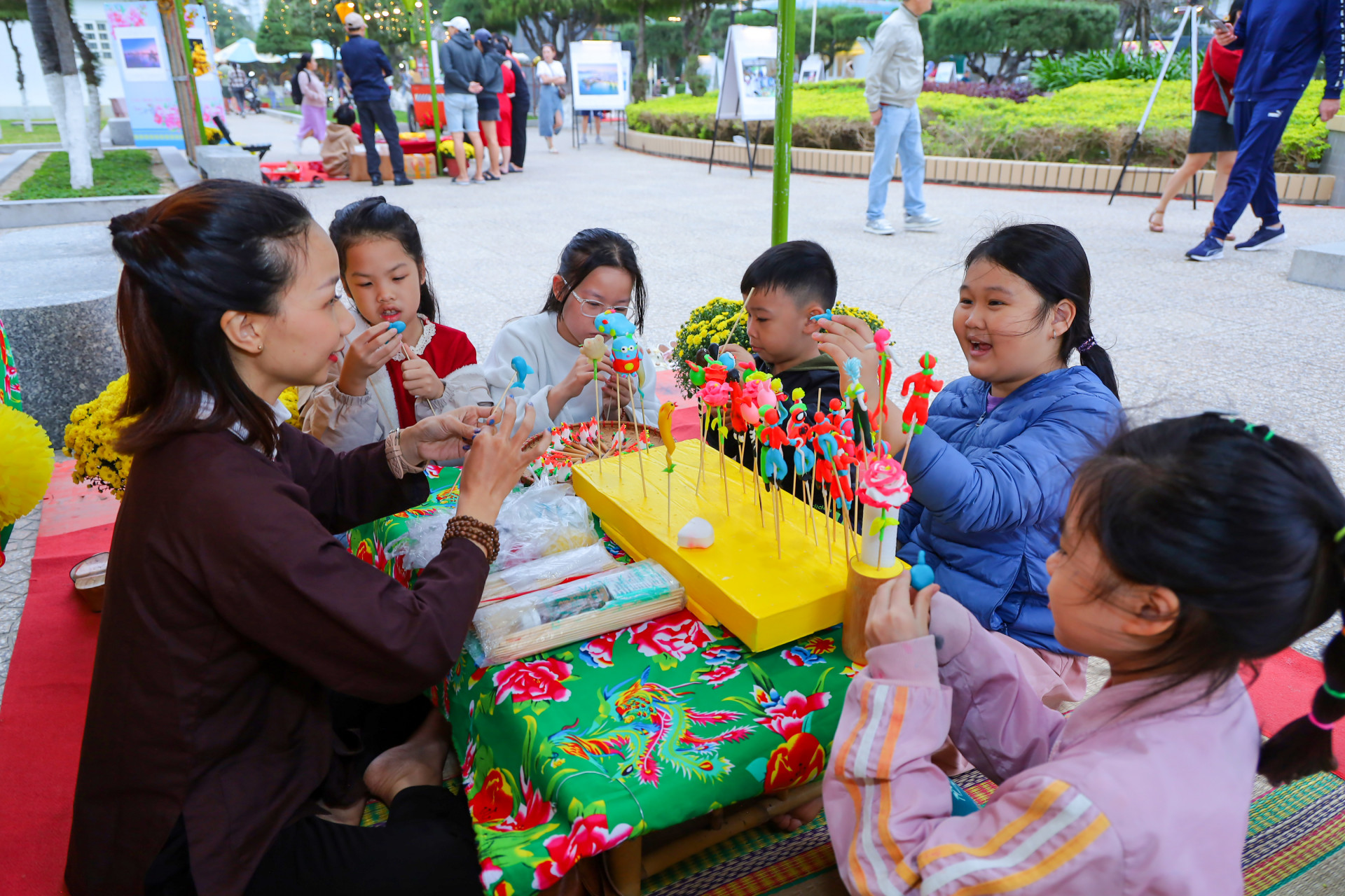 Children enjoy playing with “to he”, a traditional toy in Vietnam, at the coastal park on Tran Phu Street 