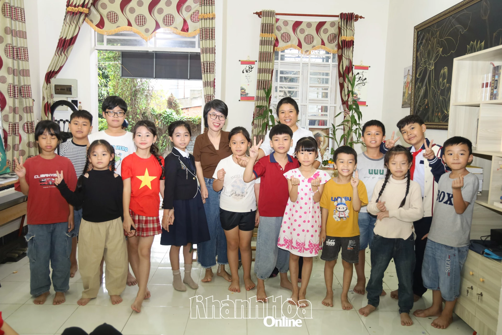 Các em nhỏ chụp hình với nhà văn khuyết tật Nguyễn Thị Kim Hòa và chị Hải Bình.