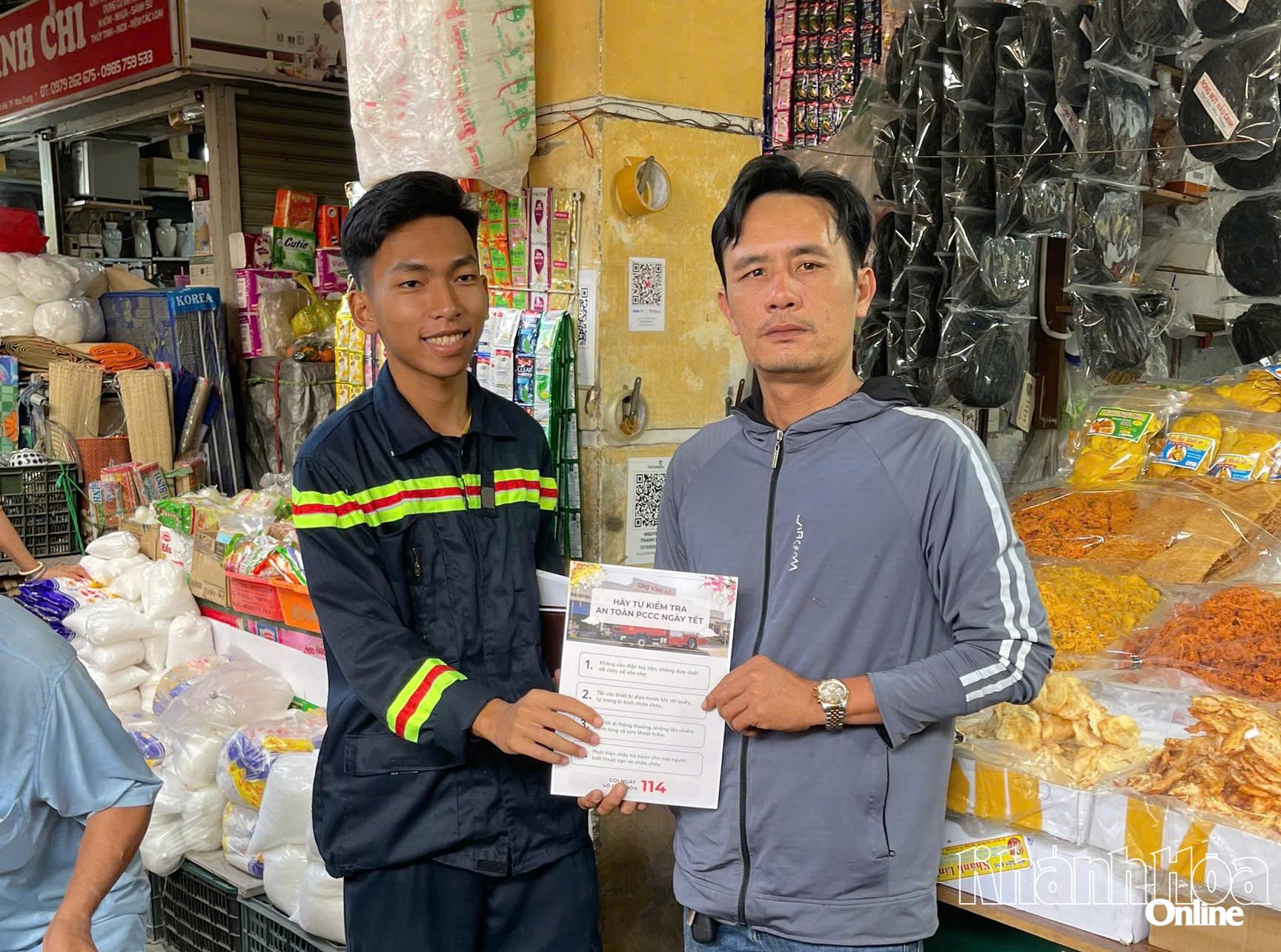 Chiến sĩ chữa cháy phát tờ rơi phòng ngừa cháy nổ cho các tiểu thương.