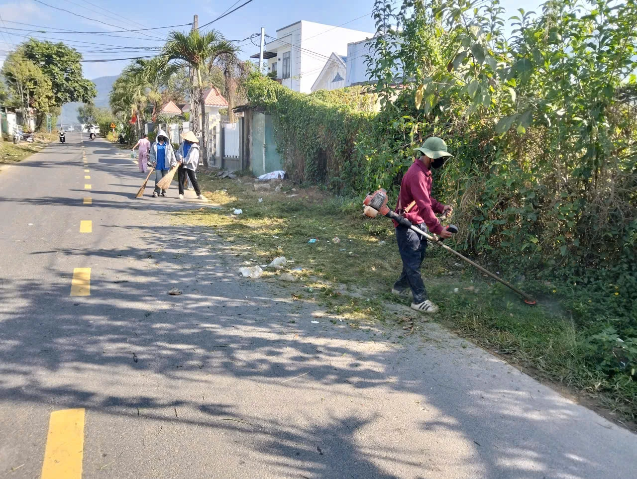 Phụ nữ Đông Khánh Sơn và người dân địa phương phát quang bụi rậm, quét dọn và thu gom rác thải.