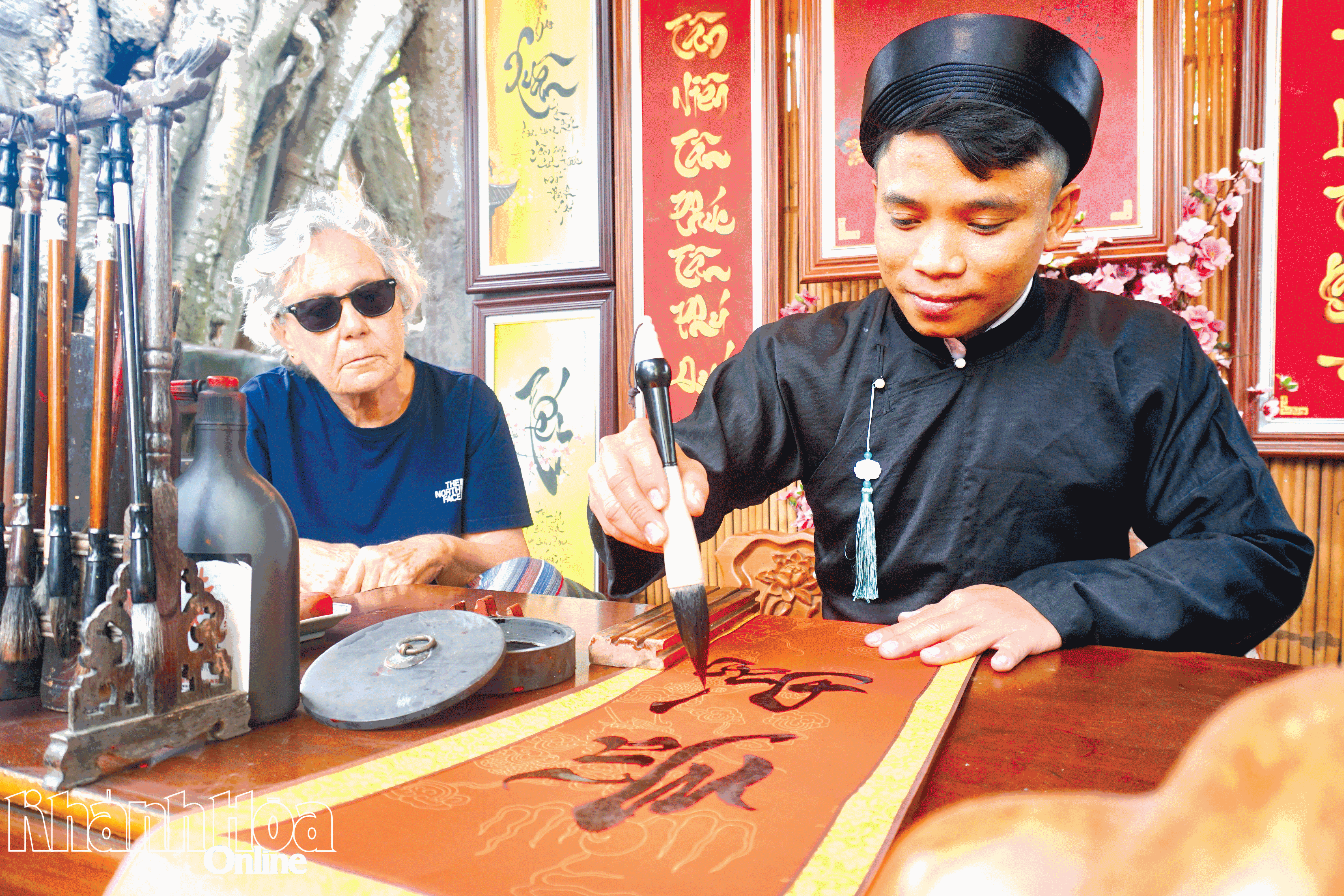 Bà Semra, du khách đến từ Thổ Nhĩ Kỳ chăm chú theo dõi những nét chữ thư pháp.