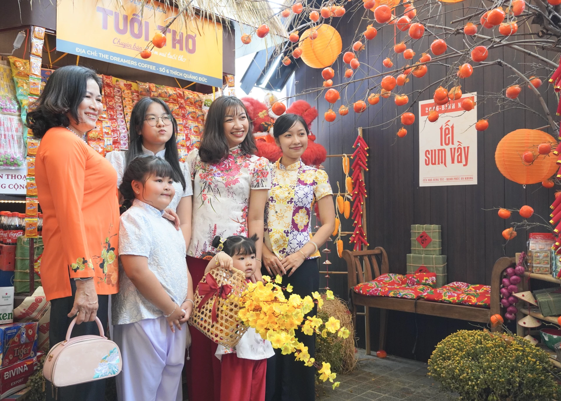 Bà Dâng (áo cam) cùng gia đình cũng chọn không gian Tết xưa để chụp ảnh và lưu giữ kỷ niệm.