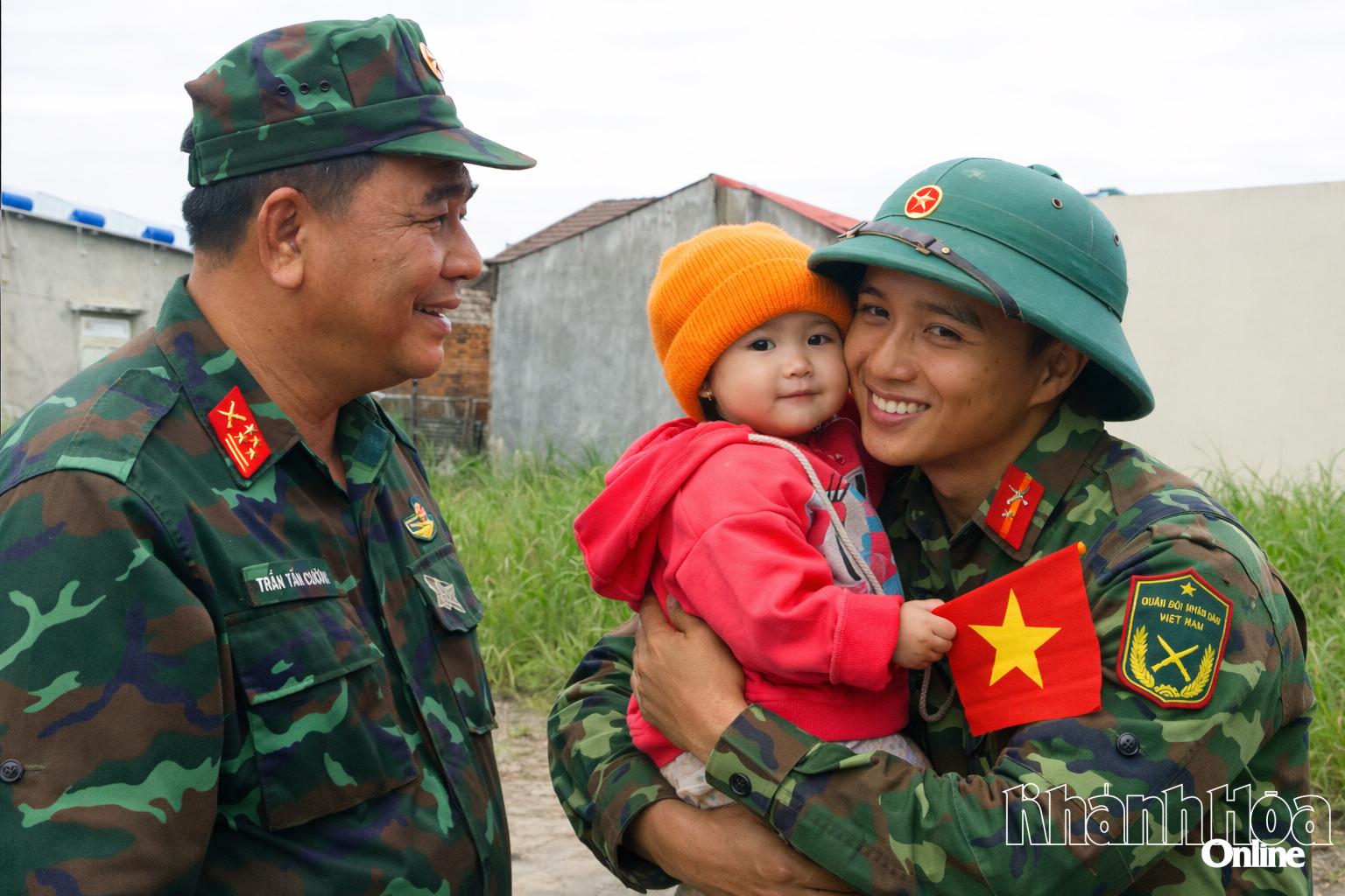 Trước giờ chia tay,
những người lính
bịn rịn
bên một em bé
tại xã Suối Hiệp.