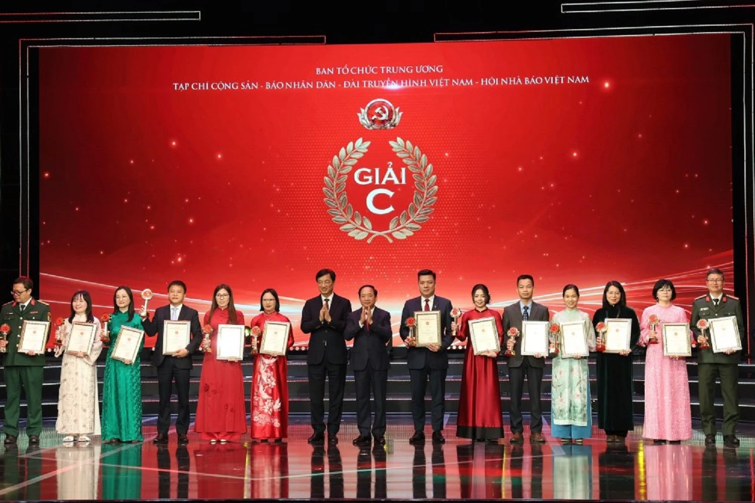 Ủy viên Bộ Chính trị, Bí thư Trung ương Đảng, Trưởng Ban Tuyên giáo và Dân vận Trung ương Trịnh Văn Quyết; Ủy viên Bộ Chính trị, Bí thư Thành ủy Hà Nội Nguyễn Duy Ngọc trao giải C cho các tác giả, đại diện nhóm tác giả đoạt giải (Tác giả Vũ Thị Hoa - Báo và Phát thanh, Truyền hình Khánh Hòa thứ tư từ phải qua).
