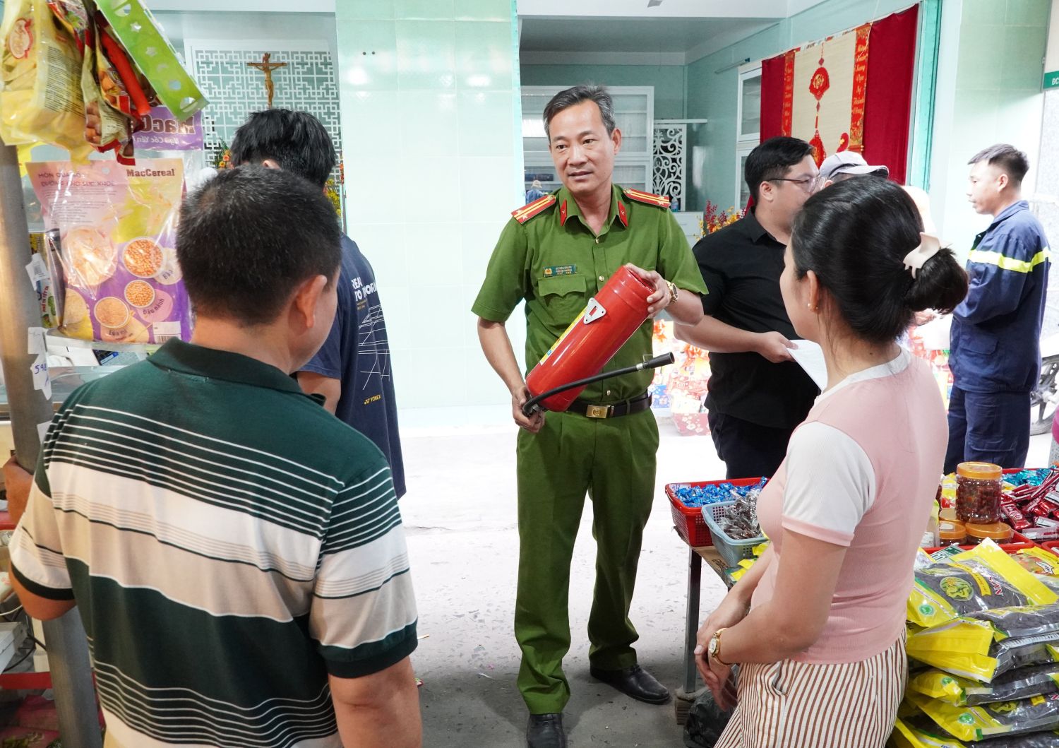 Tuyên truyền và hướng dẫn sử dụng bình chữa cháy cầm tay cho các tiểu thương tại chợ Cam Đức.