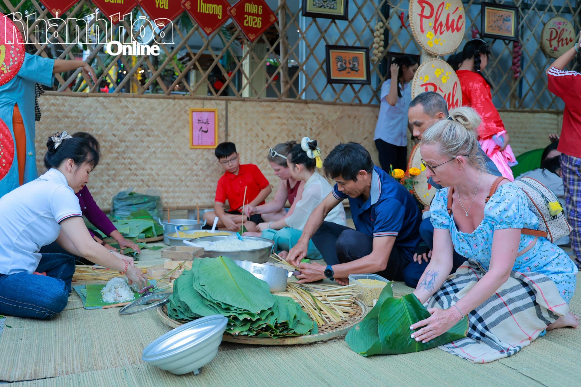 Một du khách nước ngoài học cách gói bánh chưng.