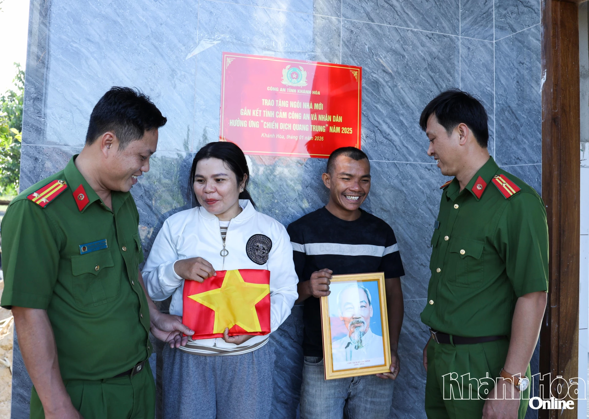 Trong ngày nhận nhà mới, gia đình ông Trương Chín (xã Hòa Trí) vui mừng được Công an xã tặng cờ Tổ quốc và ảnh Bác Hồ.