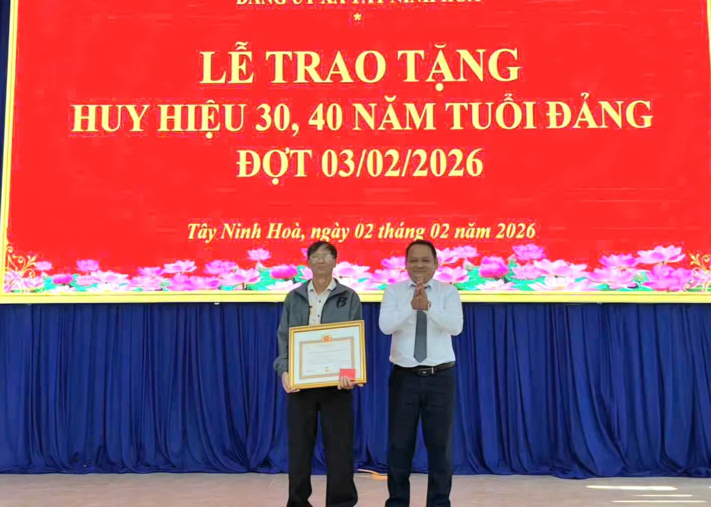 Phó Bí thư Thường trực Đảng ủy xã Nguyễn Ngọc Hiếu trao Huy hiệu cho đảng viên Đặng Văn Dũng