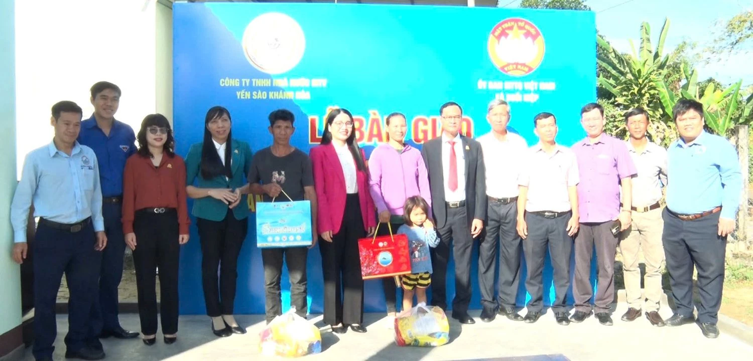 Lãnh đạo Mặt trận xã Suối Hiệp và Công ty TNHH Nhà nước Một thành viên Yến sào Khánh Hòa tặng quà cho các hộ gia đình tại lễ bàn giao.
