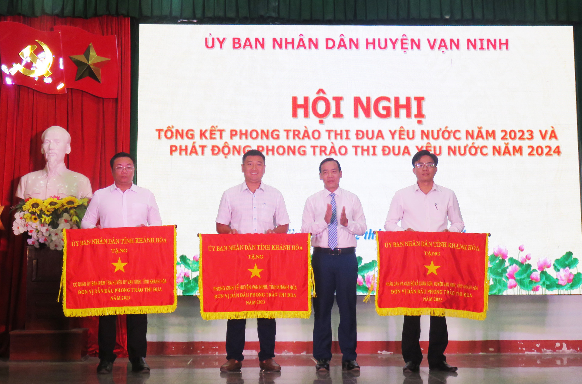 Lãnh đạo huyện Vạn Ninh trao cờ thi đua của UBND tỉnh cho các tập thể.