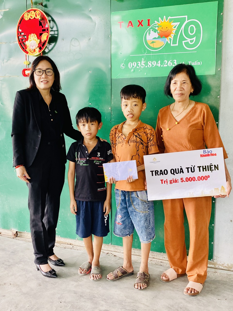 Đại diện Công ty Cổ phần Đầu tư Champagroup - Khu du lịch Champa Island Nha Trang trao tiền ủng hộ cho gia đình 2 cháu Nguyễn Đức Duy và Nguyễn Duy Khang