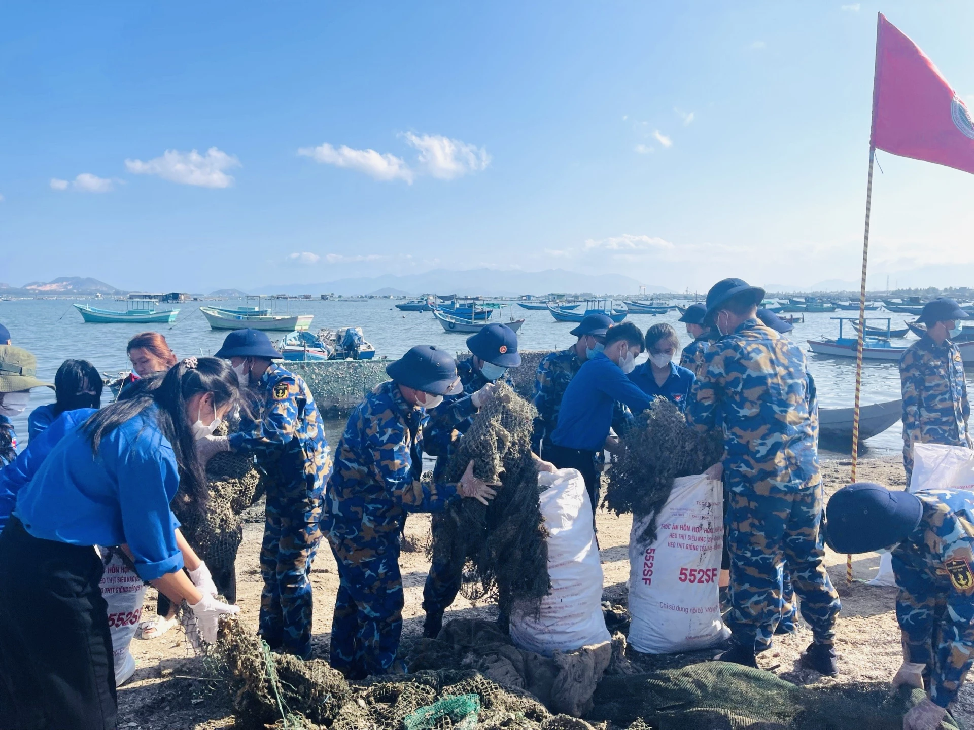 Đoàn viên thanh niên hai đơn vị ra quân dọn rác thải khu vực bờ biển.