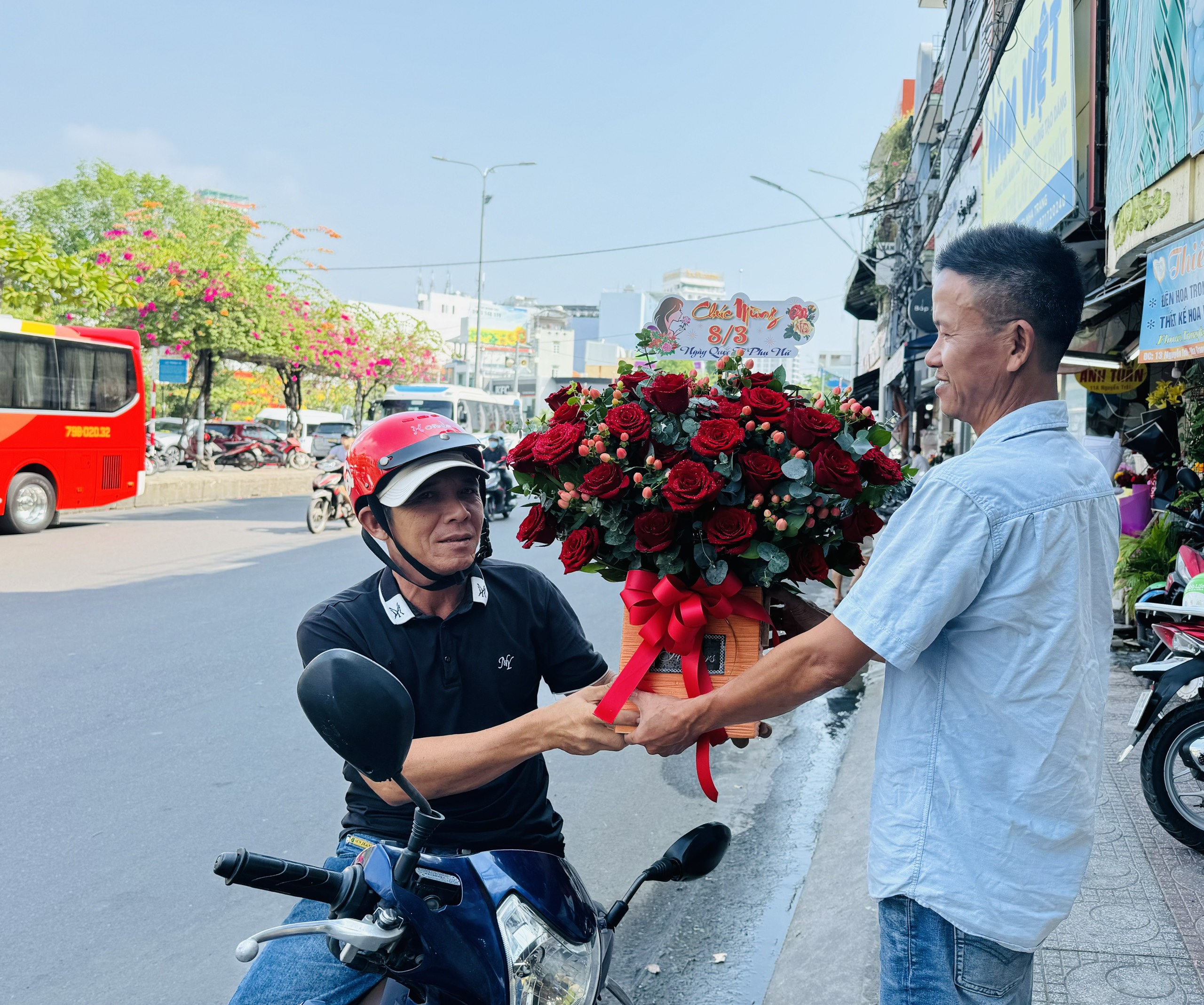 Một khách hàng nhận hoa đã đặt trước tại cửa hàng hoa Tường Vy đường Nguyễn Trãi