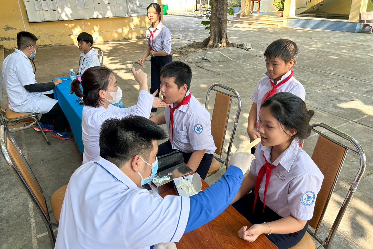 Các thầy thuốc trẻ khám sức khoẻ răng miệng cho học sinh ở đảo.