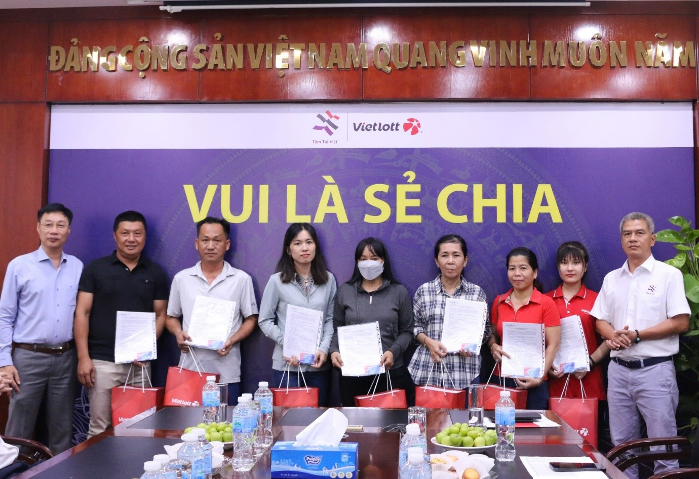 Đại diện Vietlott và quỹ Tâm Tài Việt trao tặng bảo hiểm sức khỏe đến người bán vé số