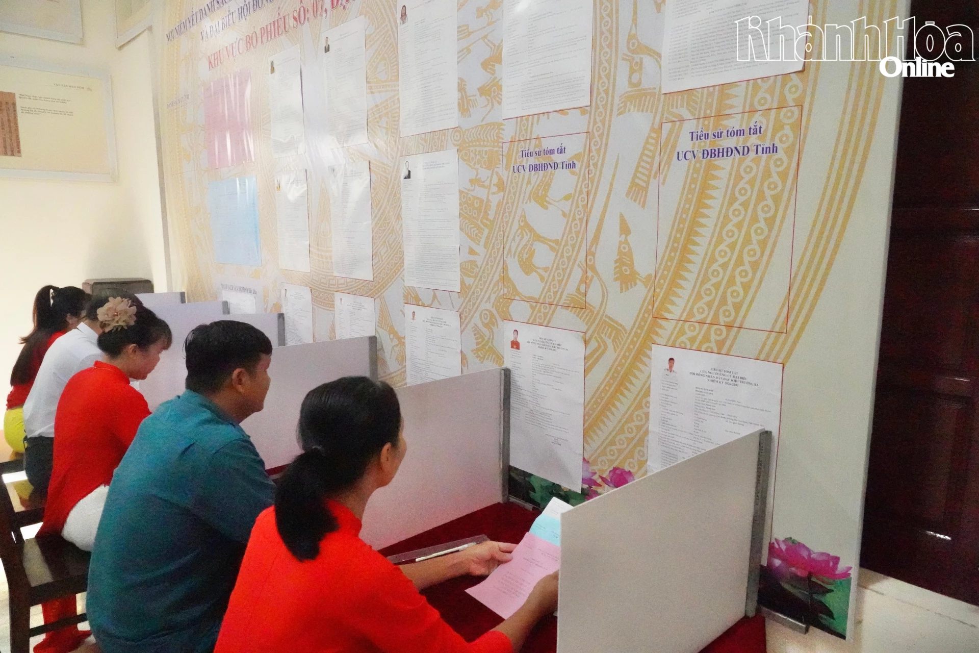 Các cử tri nghiên cứu tiểu sử đại biểu tại khu vực viết phiếu kín.